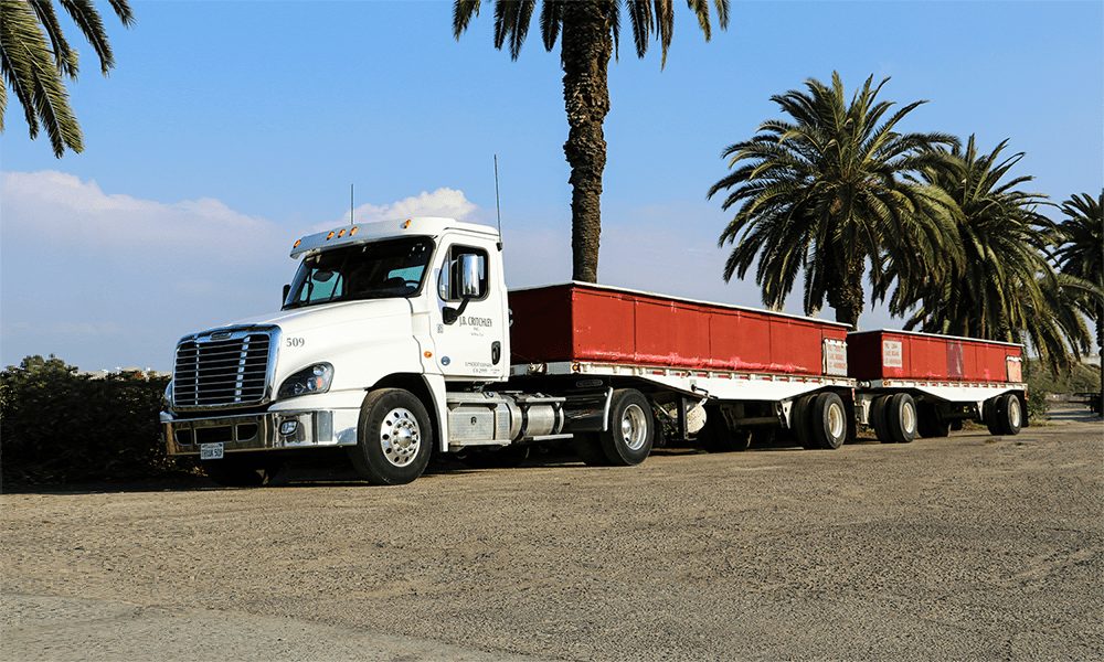 J.B. Critchley truck hauling red double trailers
