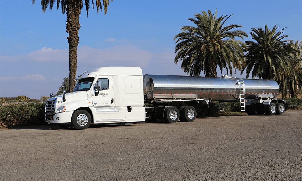 White J.B. Critchley truck pulling a stainless steel tanker trailer