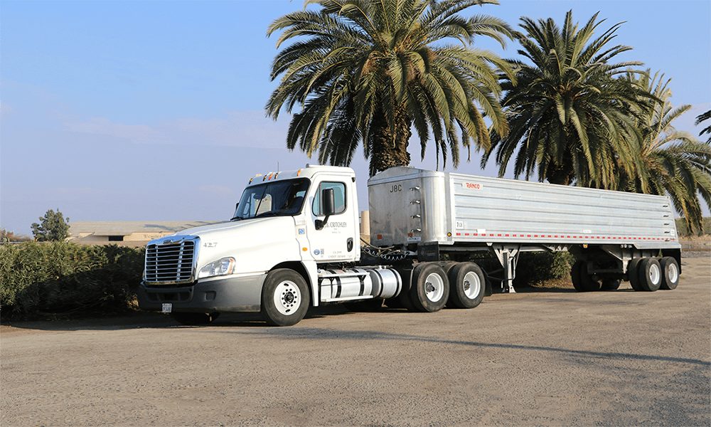 White J.B. Critchley truck pulling an aluminum end-dump trailer
